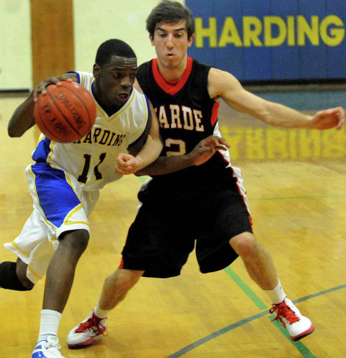 Harding's #11 Steven Walker, left, tries to get past Fairfield Warde's Matthew McTague, during boys basketball action in Bridgeport, Conn. on Tuesday January 3, 2011.