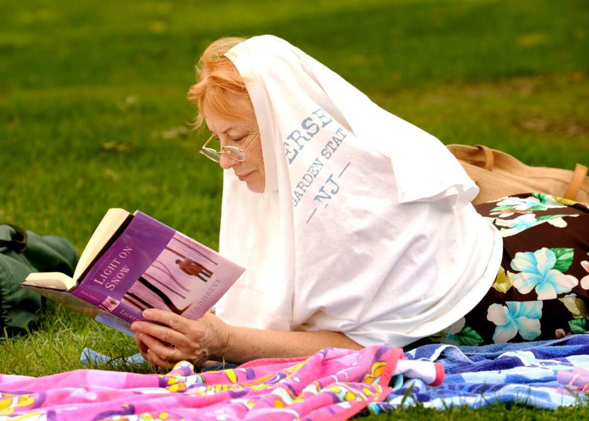 Jean MacKenzie, of Bethel, takes shelter from the sun, while relaxing at the beach, at Candlewood Shores in Brookfield on Aug.24,2009.