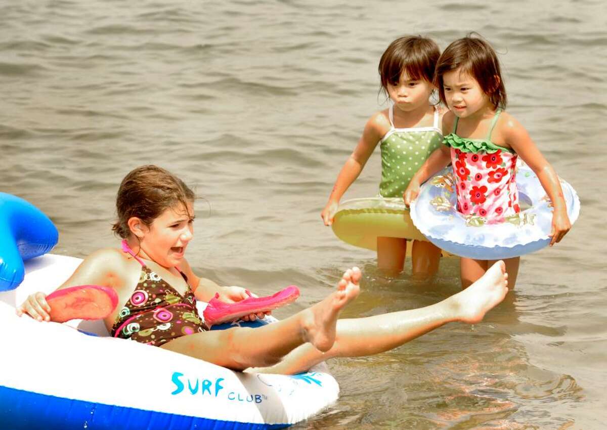Isabela Scaglione, 9, of the Bronx, struggles to remain upright while twin sisters Vivian, left, and Olivia Aldrich, 4, of Brookfield watch, at the beach in Candlewood Shores in Brookfield on Aug.24,2009.