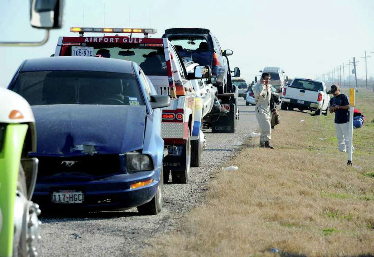 People stand along Texas 73 highway in Port Arthur, Texas, Thursday, Jan. 5, 2012. A pileup involving dozens of vehicles left more than 50 people hurt, four critically, as fog and smoke washed over a Southeast Texas officials said. (AP Photo/ The Beaumont Enterprise, Guiseppe Barranco)