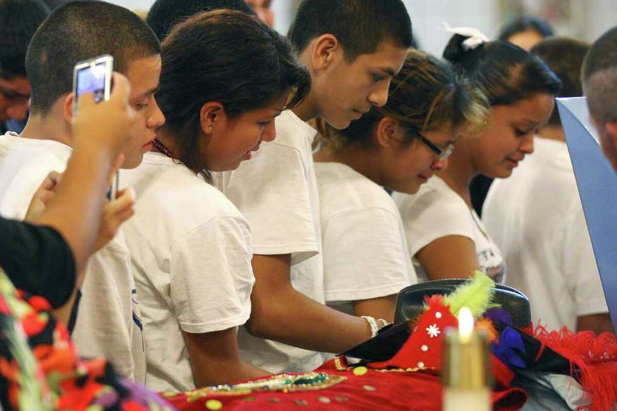 Fellow Cummings Middle School students pass Jaime Gonzalez Jr.’s casket as they gather at Holy Family Church in Brownsville for a memorial Mass. The funeral for the 15-year-old is scheduled for Saturday.