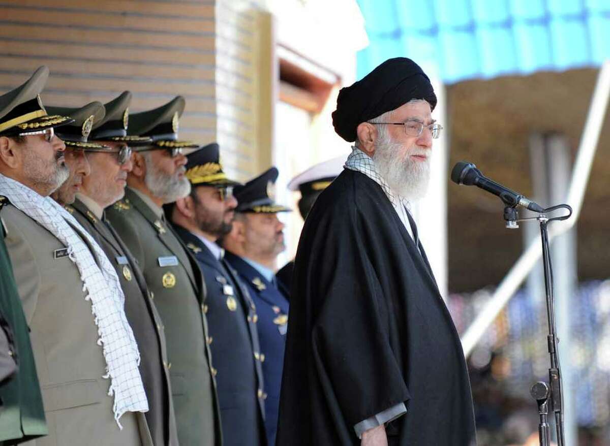 FILE - In this Thursday, Nov. 10, 2011 file photo released by the official website of the Iranian supreme leader's office, Iranian supreme leader Ayatollah Ali Khamenei, right, stands at the podium in front of high ranking armed forces members, during a ceremony in a military university, in Tehran, Iran. During a graduation at Iran's main army academy, the country's leader effectively sketched out the Islamic Republic's tougher military posture. Iran's must never hesitate to display its power in a hard-edged world where the weak pay the price, he told the newly minted officers. Less than two months later, Khamenei's words were echoed by commanders who warned that Iran could block oil tanker shipping lanes in the Gulf in retaliation for sanctions and described foreign forces _ including a recent visit by an U.S. aircraft carrier _ as unwelcome interlopers in the region. (AP Photo/Office of the Supreme Leader, File) EDITORIAL USE ONLY NO SALES