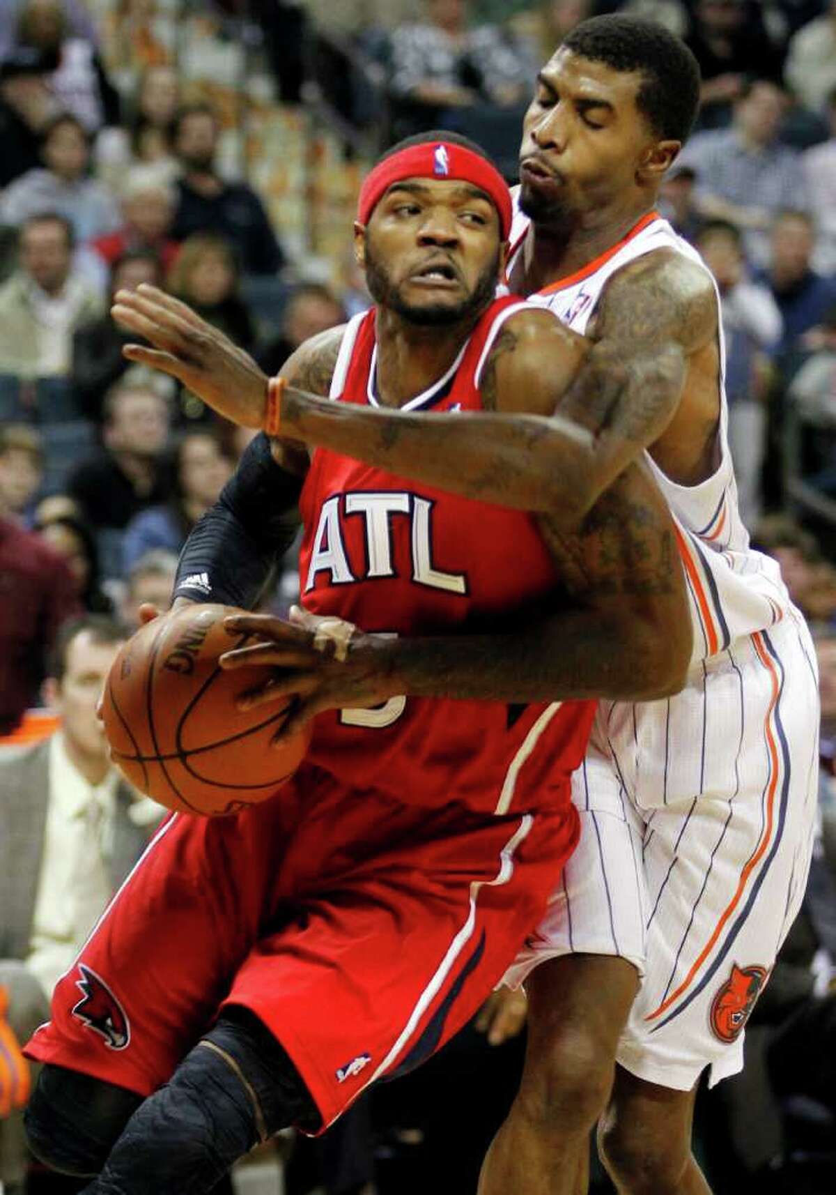 Atlanta's Josh Smith, left, muscles past Charlotte's Tyrus Thomas during the Hawks' overtime victory over the Bobcats on Friday in Charlotte.