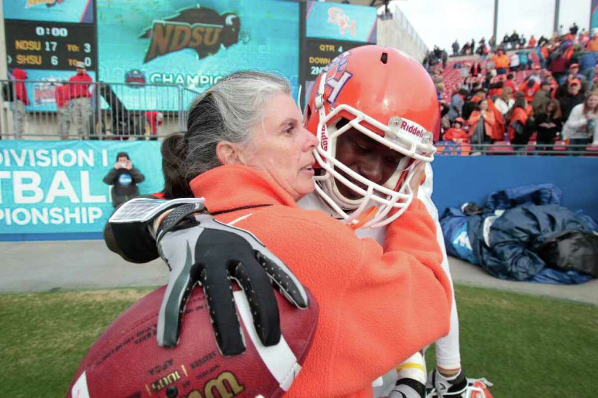 Sam Houston State University Assistant Athletic Director Chris Thompson consoles Sam Houston State University running back Tim Flanders (20). After Sam Houston State University losses to North Dakota State University in the 2012 Division I Football Championship at Pizza Hut Park in Frisco, Texas January 7, 2011.