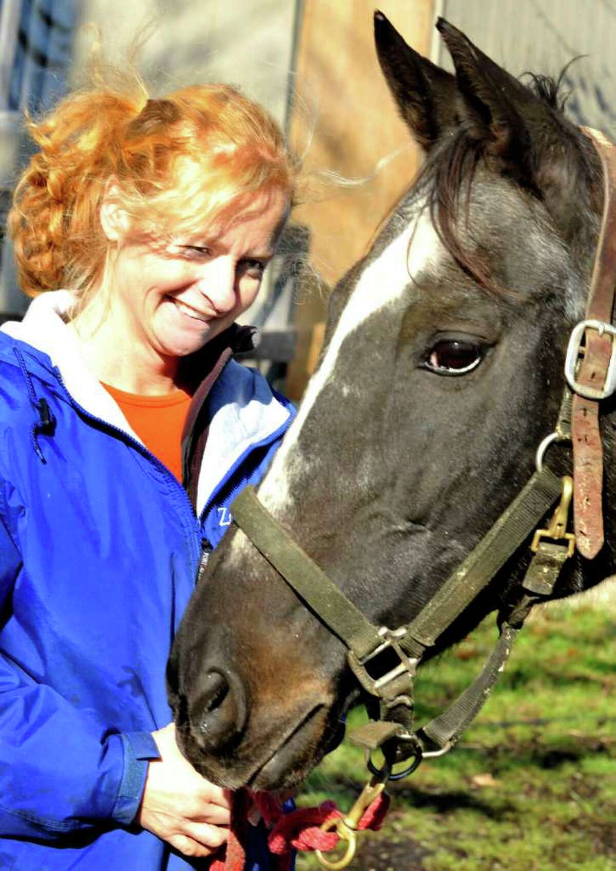 Annette Sullivan stands with Burma's Lady, the horse she rescued from slaughter, at her Zoar Ridge Stables in Newtown Thursday, Dec. 8, 2011.