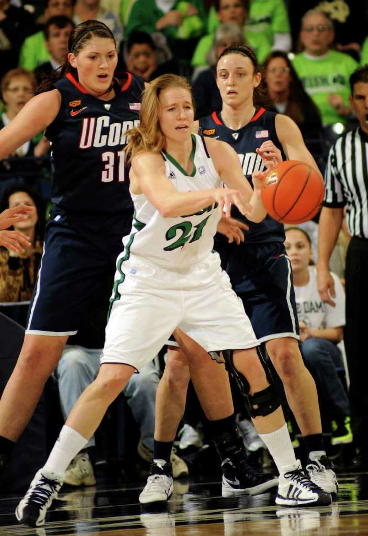 Notre Dame guard Natalie Novosel, center, pass the ball as Connecitcut center Stefanie Dolson, left, and Kelly Faris defend during the first half of an NCAA college basketball game, Saturday, Jan. 7, 2012, in South Bend, Ind. (AP Photo/Joe Raymond)
