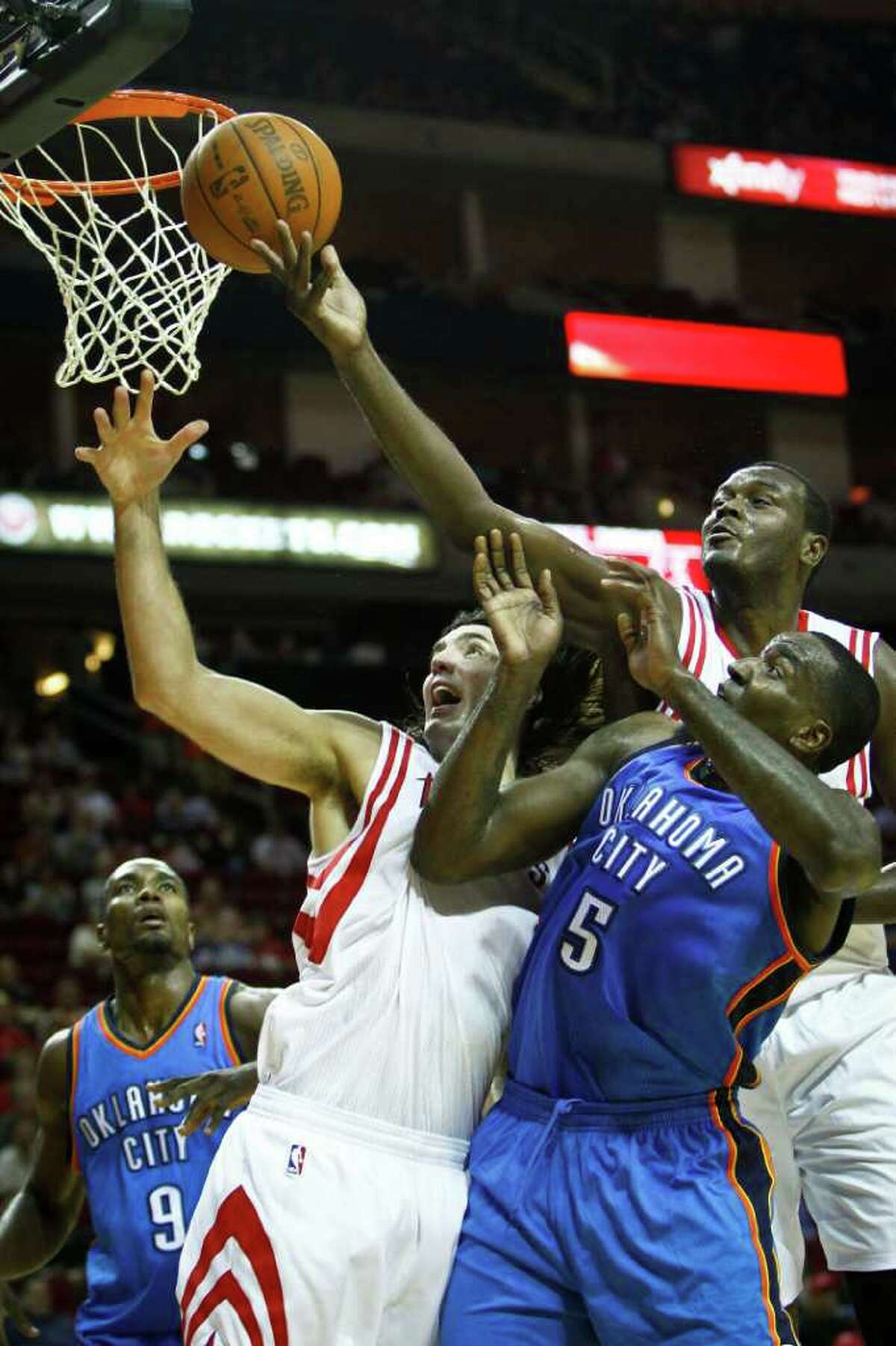 Rockets center Samuel Dalembert, right, crashes the glass over teammate Luis Scola, center, and the Thunder's Kendrick Perkins. Dalembert had four boards.