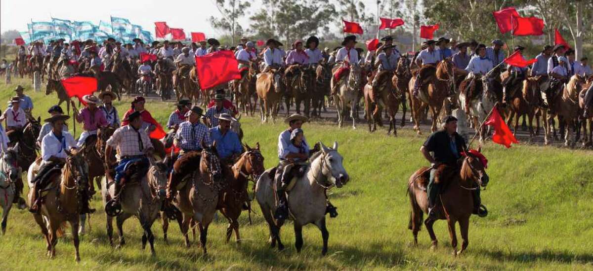 Men ride their horse towards the sanctuary of the legendary figure 'Gauchito Gil,' to mark the anniversary of death, near Mercedes, in Argentina's Corrientes state, Sunday Jan. 8, 2012.
