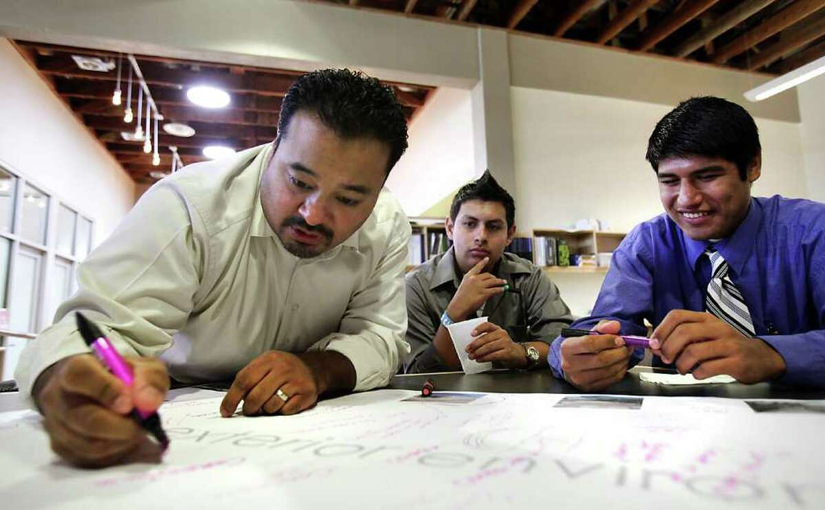 Fernando Flores, left, an architect with OCO Architects, writes notes during a meeting with The Highlands High School Engineering, Architecture and Construction Team, including Eleazar Robles, center, and Leonardo Rocha, right. The students met with architects from Pfluger and OCO Architects, to give ideas for the bond funded renovation of the high school. Wednesday, Nov. 30, 2011. Photo Bob Owen/rowen@express-news.net