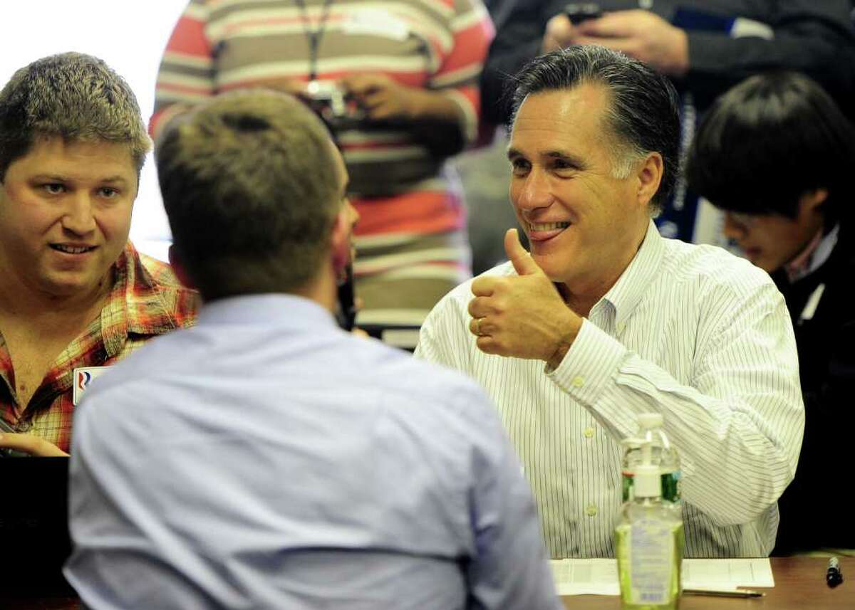Republican presidential hopeful Mitt Romney gives a thumb up as he joins volounteer to call potential voters at his New Hampshire headquarters in Manchester, New Hampshire, on January 9, 2012. New Hampshire will hold its Republican primaries on January 10, 2012. AFP PHOTO/Emmanuel Dunand (Photo credit should read EMMANUEL DUNAND/AFP/Getty Images)