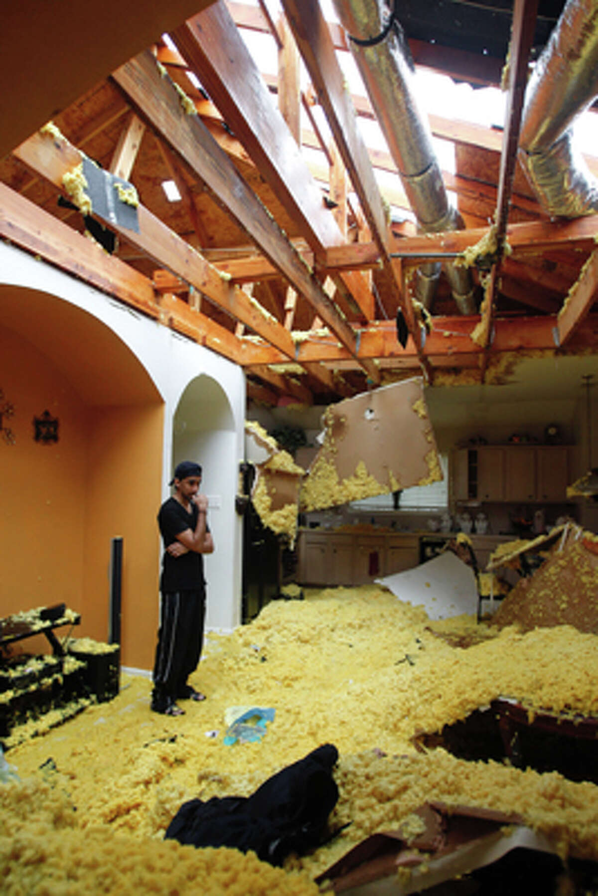 Umair Sayyed looks over damage by a possible tornado inside the home where his he lives with his family in the 15000 block of Turphin Way Monday, Jan. 9, 2012, near Sugar Land.