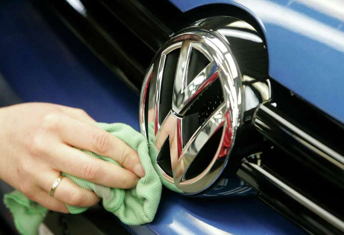 FILE - In this March 8, 2010 file picture, a worker cleans a Volkswagen logo in the production line at the Volkswagen plant in Wolfsburg, German automaker Volkswagen AG says it saw group sales of more than 8 million vehicles last year, putting it ahead of Japan's Toyota Motor Corp. Germany's dapd news agency cited Volkswagen CEO Martin Winterkorn on Monday, Jan. 9, 2012, as saying in Detroit that VW had delivered 8.156 million vehicles in 2011, a 14 percent rise over the previous year. (AP Photo/dapd/Joerg Sarbach, File)