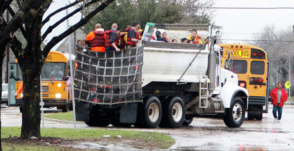 Houston Fire Department personnel use a City of Houston dump truck during high water rescue of a school near Griggs Road and Martin Luther King Boulevard Monday, Jan. 9, 2012, in Houston. ( James Nielsen / Chronicle )