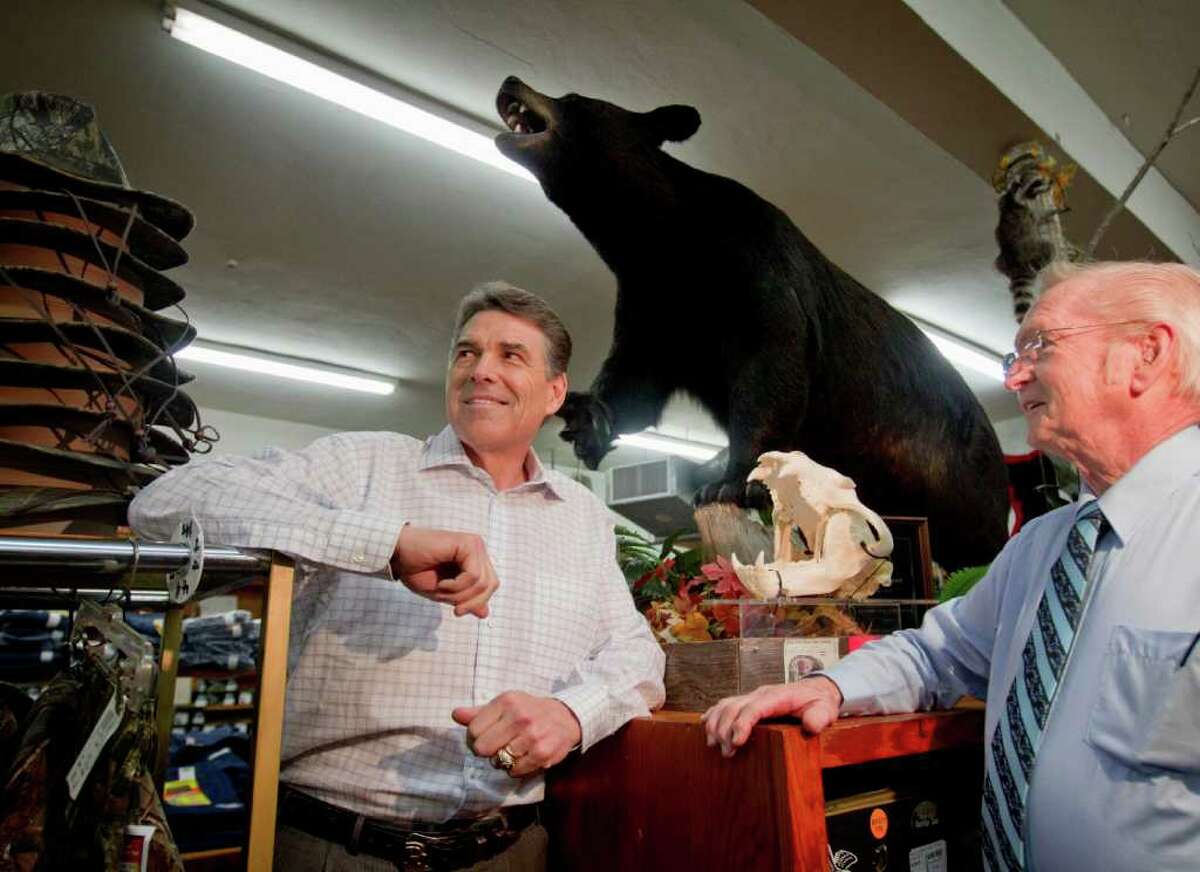 Campaigning in South Carolina on the eve of the New Hampshire vote, Republican presidential candidate Texas Gov. Rick Perry visits with Glenn Brock, owner of Brock's department store, during a stop Monday in Pickens, S.C.
