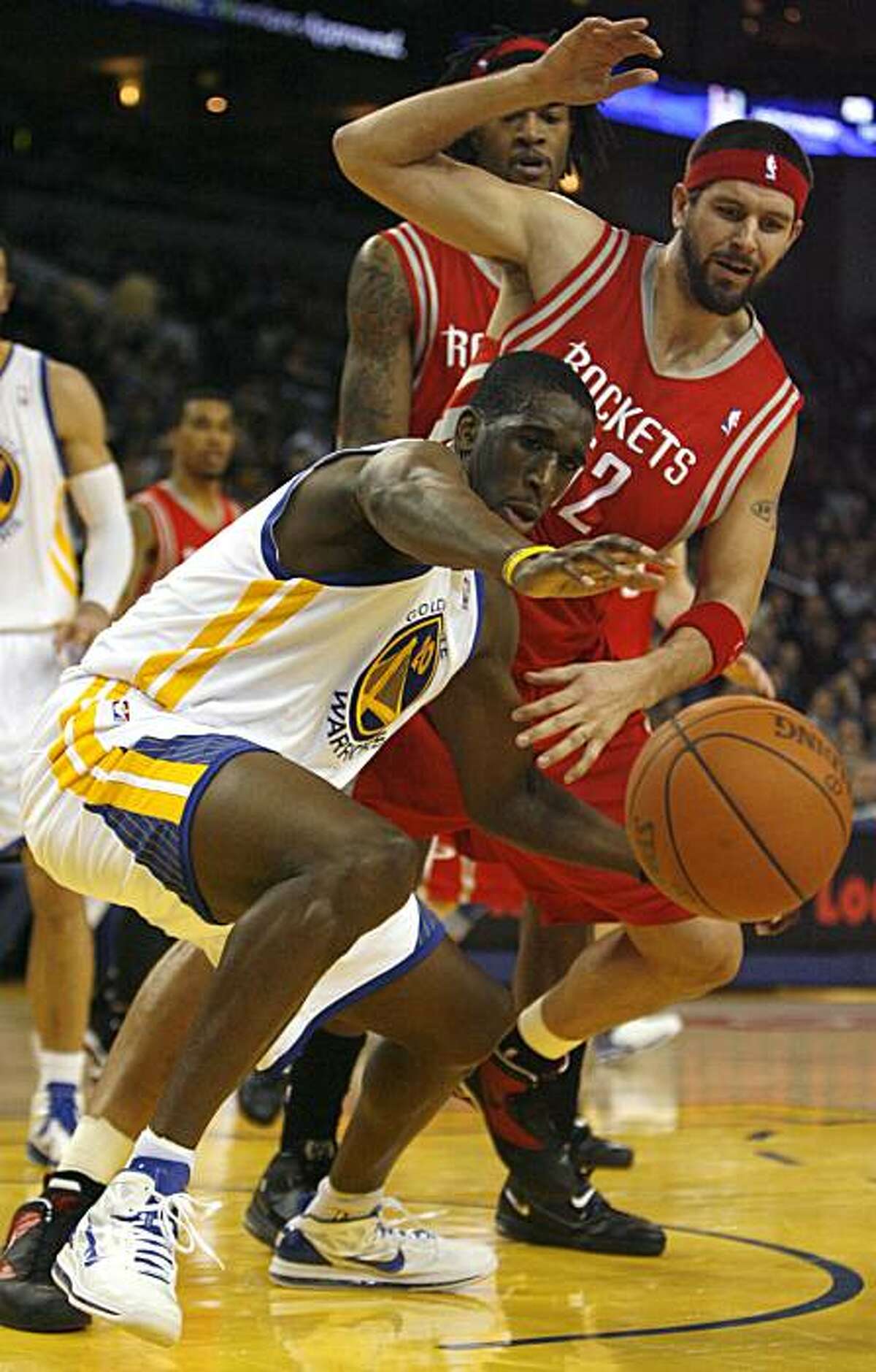 Golden Gate Warriors Ekpe Udoh, (20), tries to gain control of the ball after knocking it lose from Houston Rockets Brad Miller's hand, (52), in the first quarter, Monday, Dec. 20, 2010 at the Oracle Arena in Oakland, Calif.