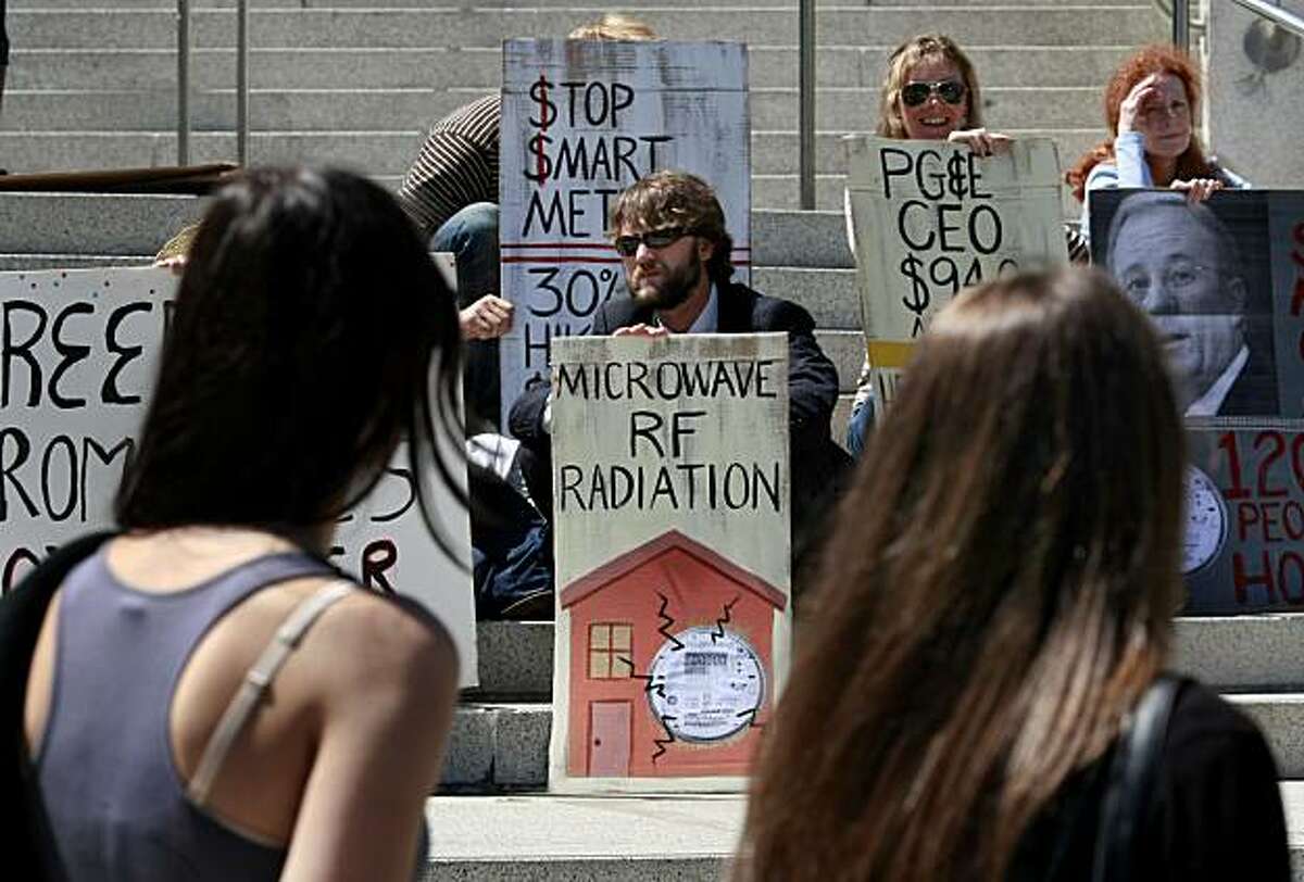 Pedestrians on Van Ness Avenue looked at the signs from the protesters upset with the smartmeter program. A meeting at the State of California building in San Francisco, Calif. by PG&E officials about smartmeters prompted a protest on the steps of the building Thursday August 12, 2010.