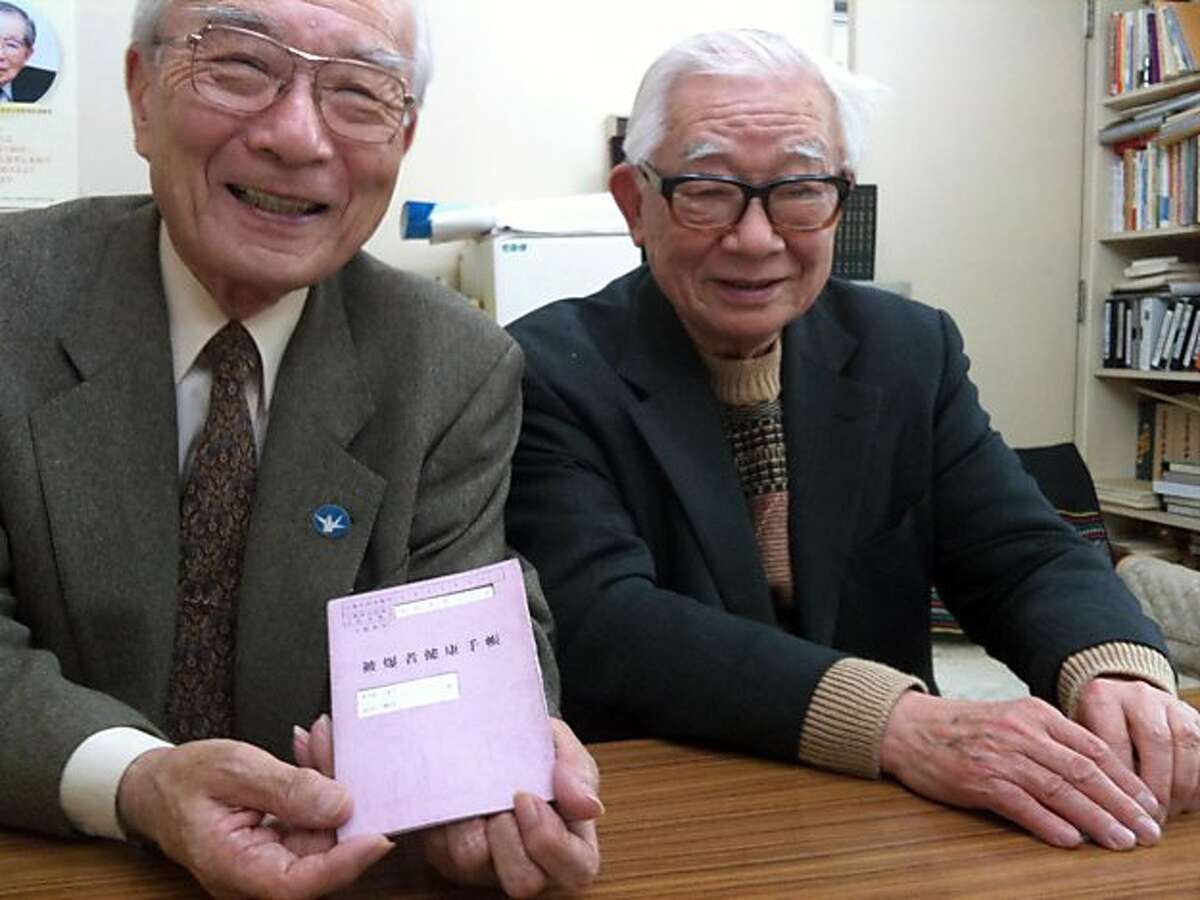 Terumi Tanaka, 78, holds his purple A-bomb health pamphlet while sitting next to fellow bomb survivor Mikiso Iwasa, in Tokyo. Illustrates JAPAN-NAGASAKI (category i), by Chico Harlan (c) 2011, The Washington Post. Moved Thursday, March 17, 2011. (MUST CREDIT: Washington Post photo by Chico Harlan.)