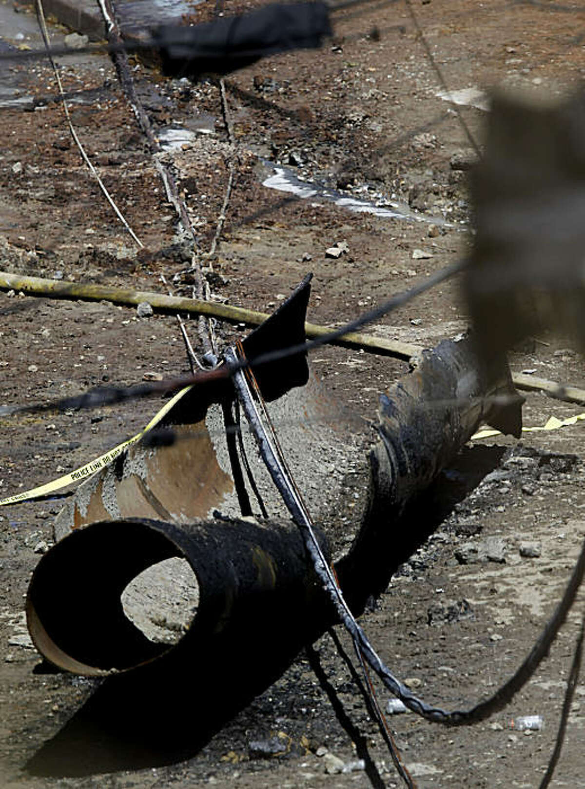 A piece of the large high pressure natural gas line, lies in the middle of the street covered with police tape, near the blast site on Friday Sept. 10, 2010, in which an explosion and fire leveled the surrounding neighborhood the night before in San Bruno, Calif.