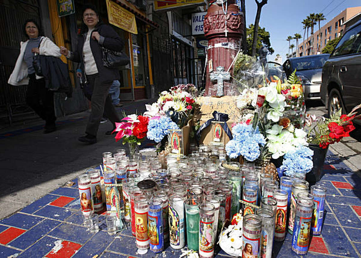 Women walk past a memorial shrine in the Mission District in San Francisco, Calif., on Thursday, March 3, 2011, at the scene of a fatal shooting last weekend.