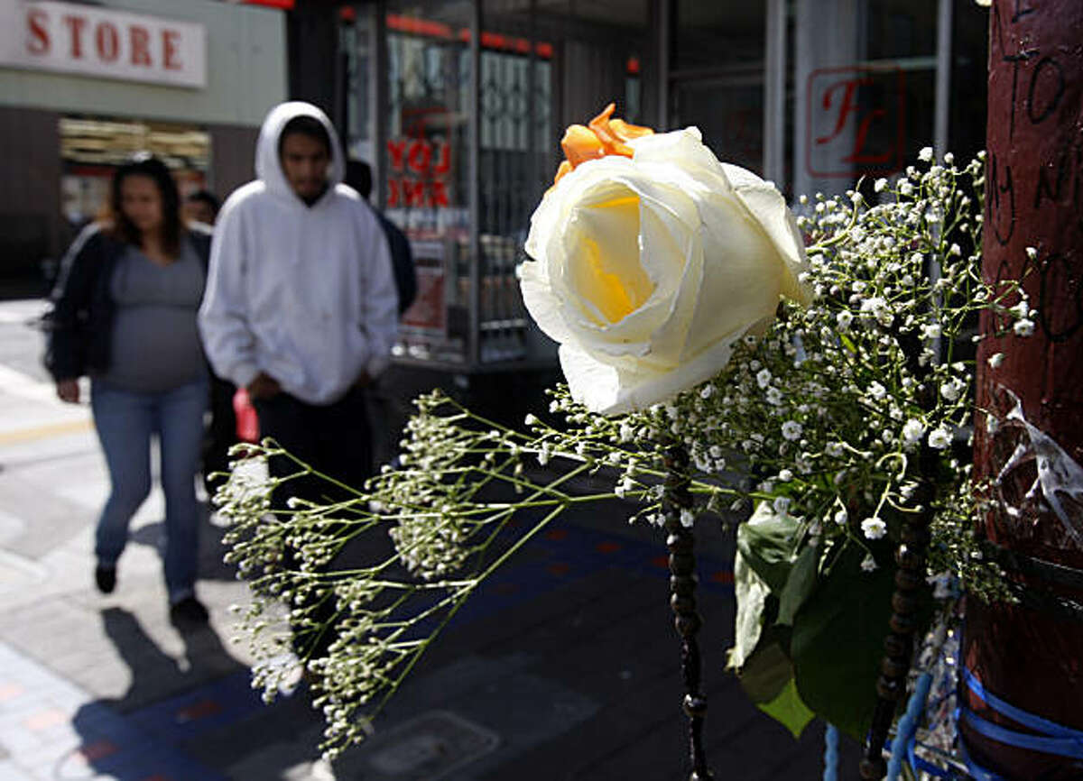 Pedestrians walk past a memorial shrine in the Mission District in San Francisco, Calif., on Thursday, March 3, 2011, at the scene of a fatal shooting last weekend in the Mission District in San Francisco, Calif., on Thursday, March 3, 2011.