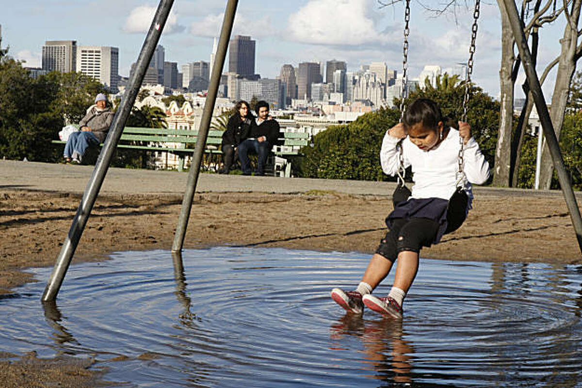 Aricelia Pablo watches the ripples underneath her as she plays on the flooded Dolores Park playground in San Francisco Calif, on Friday, Feb. 25, 2011.