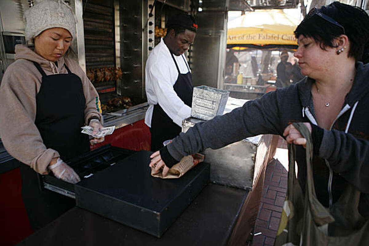 Akiko Fujii (left) and John (right, wouldn't give last name) sell roasted chicken out of the Roli Roti food truck at the UN Plaza Farmer's Market on Wednesday, February 23, 2011.