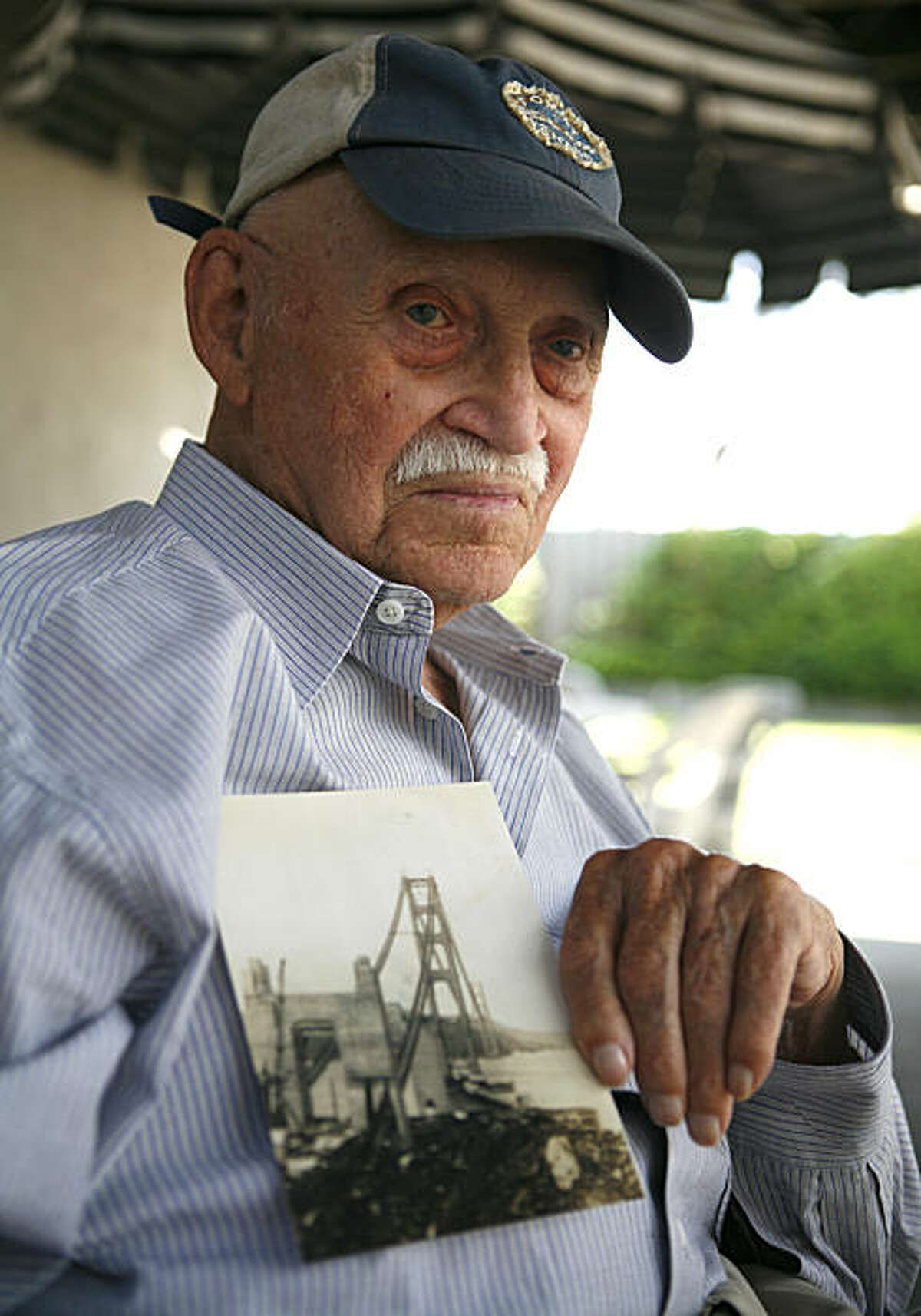97-year old Harry Fogle, one of the last original workers who worked on the Golden Gate Bridge, holds a photo of the Golden Gate Bridge while it was being built on Thursday August 6, 2010 in Citrus Heights, Calif. Fogel worked as a painter.