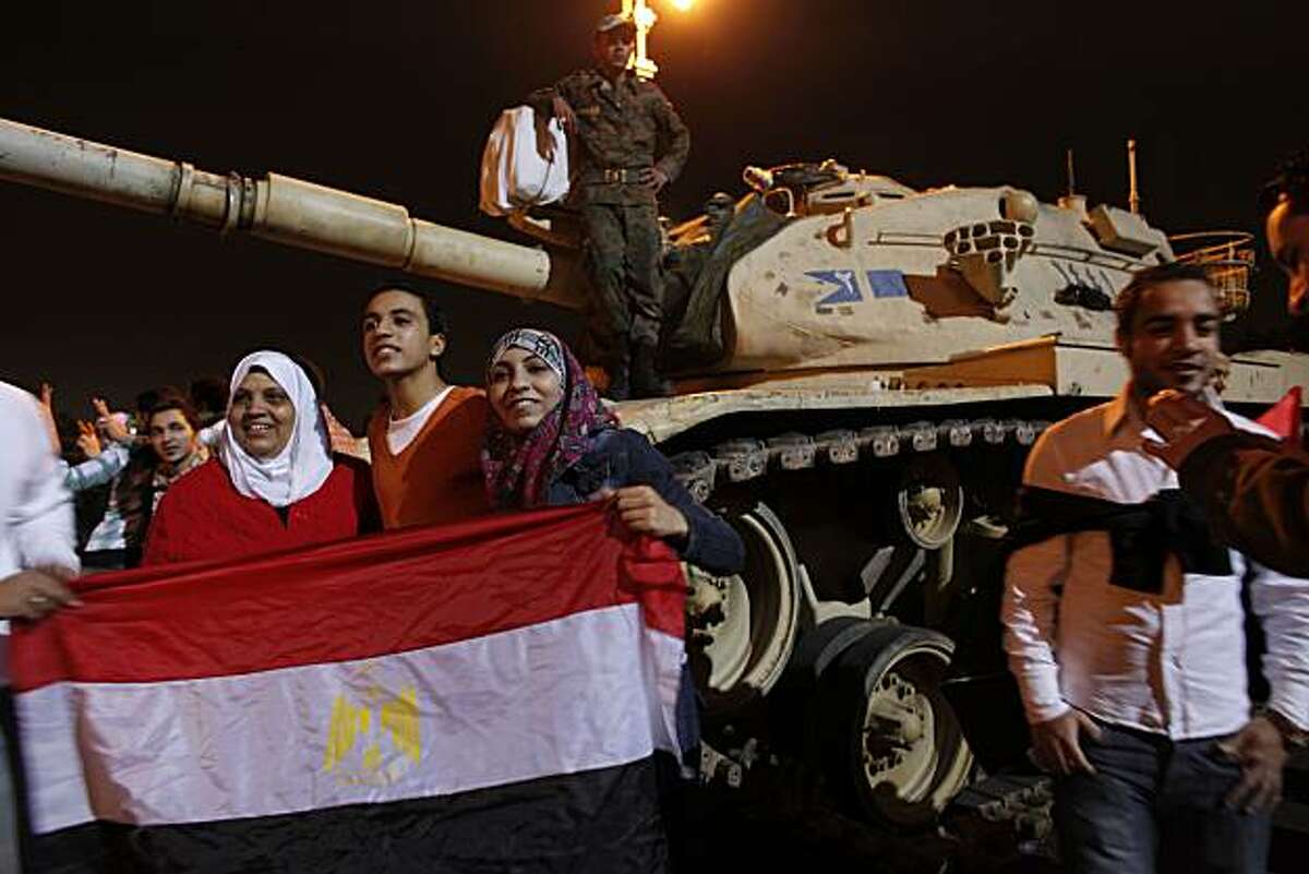 Families and protesters have their photos taken next to the Egyptian tanks as protesters erupt in joy in Cairo, Egypt's Tahrir Square following President Hosni Mubarak's announcement that he was handing power to the military on Friday, February 11, 2011. (Michael Robinson Chavez/Los Angeles Times/MCT)