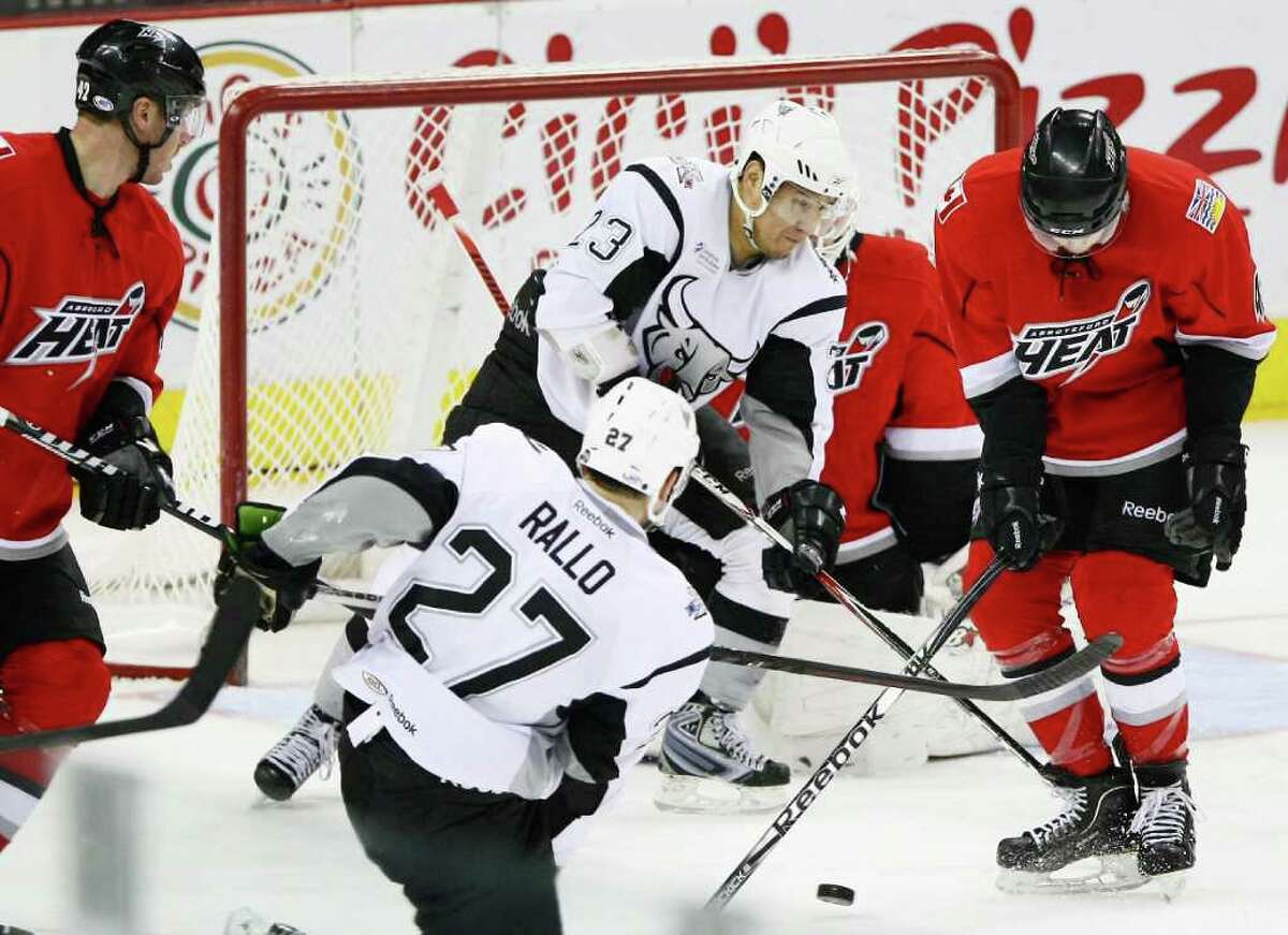 San Antonio Rampage's Wacey Rabbit (23) and Greg Rallo (27) fight for the puck with Abbotsford Heat's John Negrin, right, during the third period of an AHL hockey game, Tuesday, Jan. 10, 2012, in San Antonio. Abbotsford won 5-0.