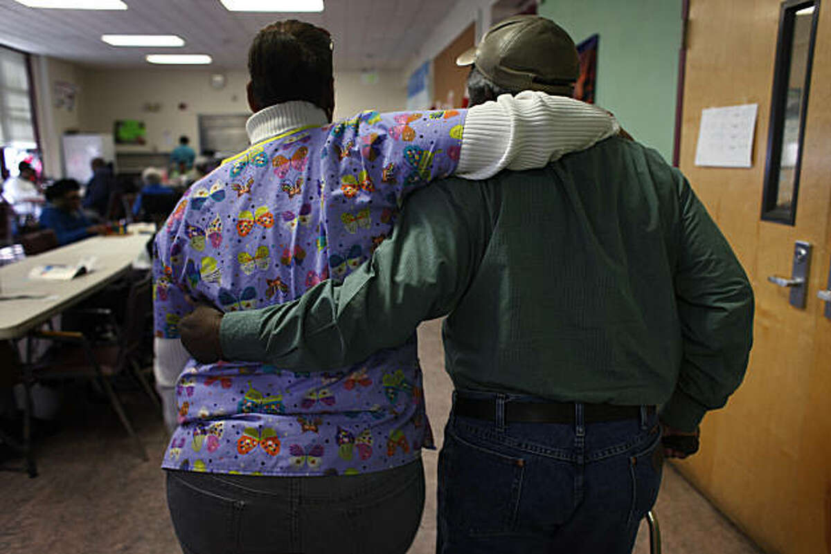 Kris Martin, a Rehab Asst. at the Bayview Hunter's Point Adult Day Health Center, walks with client Ernest Badger, 70, before lunch at the center on Thursday Feb. 3, 2010 in San Francisco, Calif. "I worry about him like he's my own family member," said Martin. "They support me here. They give me confidence," said Badger. In an effort to help save the state's budget crisis, California Gov. Jerry Brown has proposed eliminating funding for the adult day health care programs which could be potentially devastating for the 37,000 people who depend on theses programs daily.