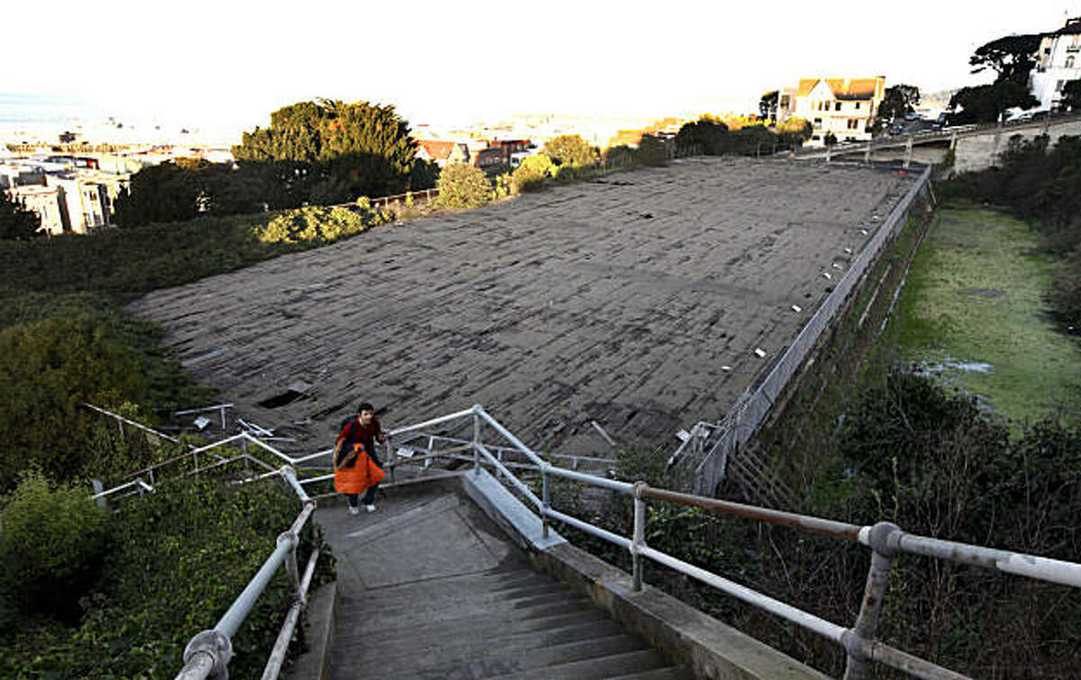 A Russian Hill visitor climbs the stairway from Bay Street to Chestnut that's ajacent to the covered Reservoir. The SFPUC is relaunching an effort to tear down their Francisco Reservoir on Russian Hill. They'd like to sell the high-value land, with panoramic views of the Golden Gate, to developers and use the cash to fund the demolition. Neighbors, though, say they deserve a park or other open space. Tuesday Jan 18, 2011.