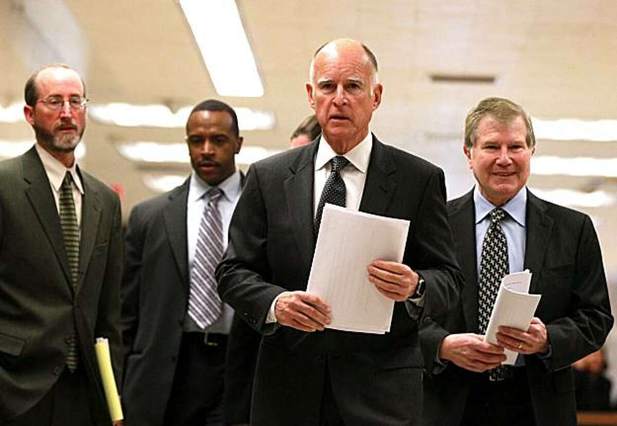 California Governor Jerry Brown (C) walks with advisors to a press conference about his proposed budget at the California State Capitol on January 10, 2011 in Sacramento, California. Governor Brown announced a balanced state budget that cuts spending by $12.5 billion and includes an eight to ten percent cut in take home pay for state employees and proposes a "vast and historic" restructuring of government operations.