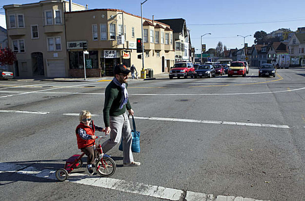 Rob Thomson helps Leo Thomson, age 2, cross Cesar Chavez Street in San Francisco, Calif., on Thursday, January 6, 2011. The city has unveiled a plan to remake the street with fewer traffic lanes, a new pedestrian plaza and new medium plantings.