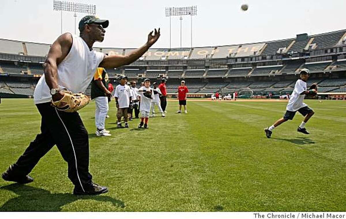 Former Oakland Athletic star Rickey Henderson tosses balls to kids of the Oakland Babe Ruth Baseball League, during the Bak of America Youth Baseball Clinic at the McAfee Coliseum in Oakland, Calif. of TUesday July 8, 2008. Photo By Michael Macor/ The Chronicle