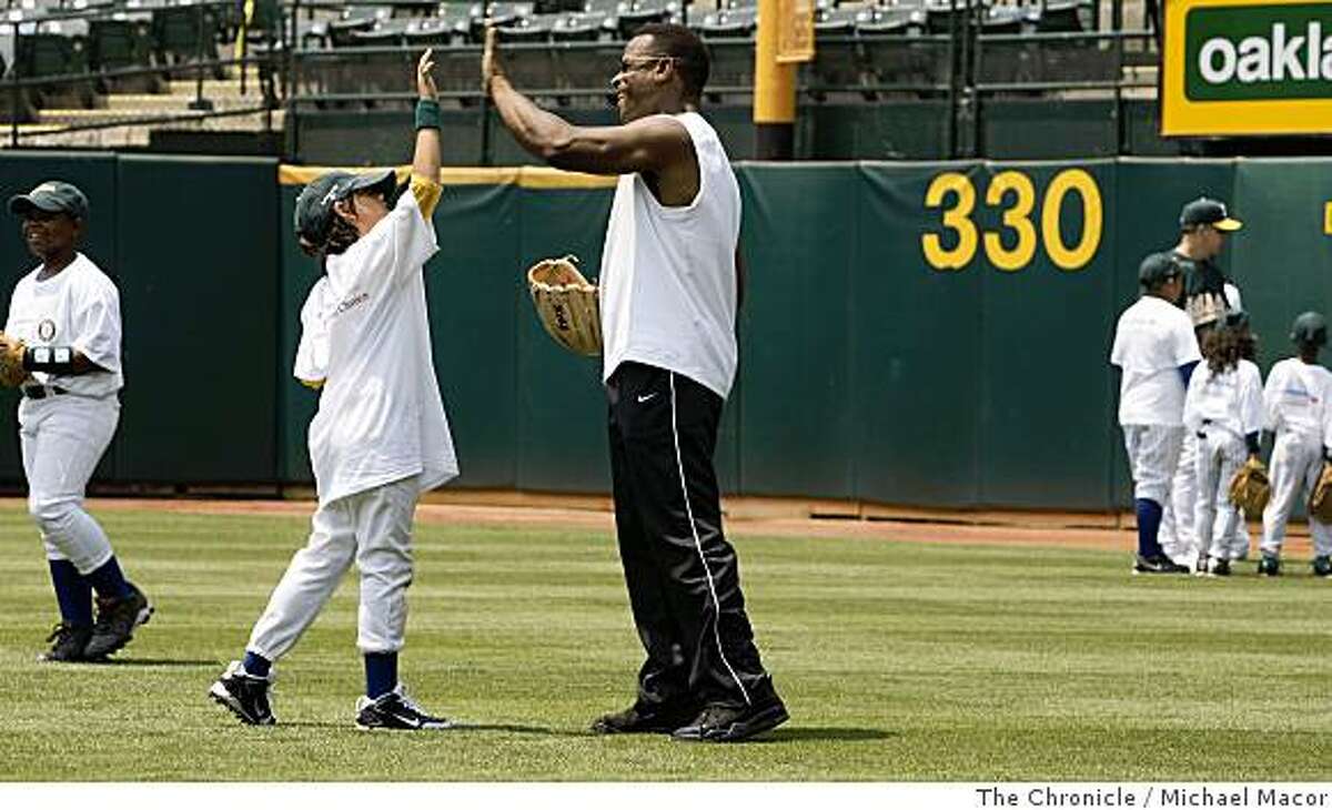 Former Oakland Athletic star Rickey Henderson gets a high-five from Albert Ybarra, 9 of Oakland ,during the Bank of America Youth Baseball Clinic at the McAfee Coliseum in Oakland, Calif., on Tuesday July 8, 2008.Photo By Michael Macor/ The Chronicle