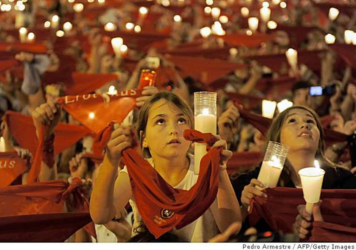 Children hold candles as they sing the 'Pobre de Mi' song, marking the end of the San Fermin festival, early July 15, 2009, in Pamplona, northern Spain. The festival is a symbol of Spanish culture, despite heavy condemnation from animal rights groups, and attracts thousands of tourists to watch the bull runs. AFP PHOTO / Pedro ARMESTRE (Photo credit should read PEDRO ARMESTRE/AFP/Getty Images)
