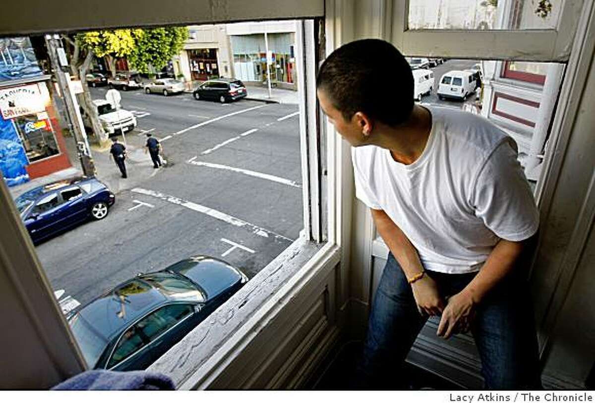 Benjamin Castaneda, 20 years old, looks outside a window from his home where he often sees norteno members hanging out, Wednesday Oct. 22, 2008, in San Francisco, Calif.