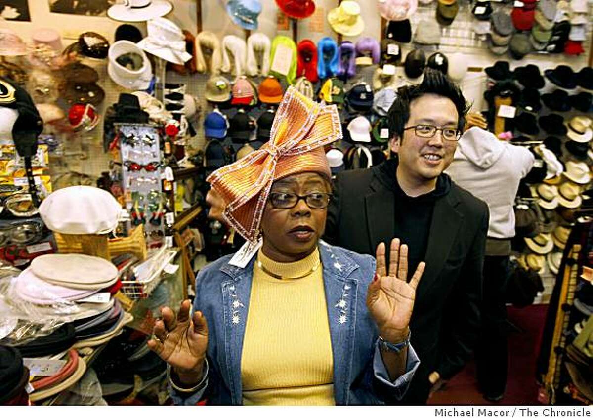Brenda Bruner, of Oakland, is helped by Luke Song, owner of "Mr. Song Millinery" in Detroit, as she tries on one of his hat designs during a visit to the Berkeley Hat Co., on Friday April 24, 2009, in Berkeley, Calif.