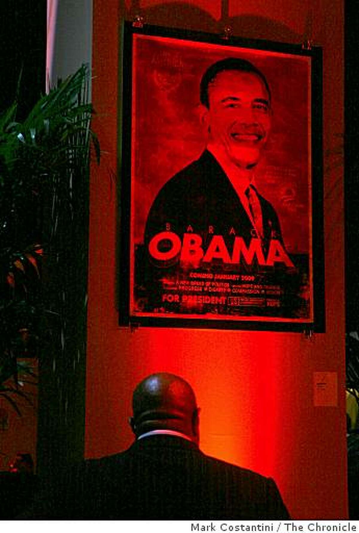 A partygoer looks at an Obama poster at the Inauguration West party celebrating the inauguration of Barack Obama at the Metreon in San Francisco, Calif. on Tuesday January 20, 2009.