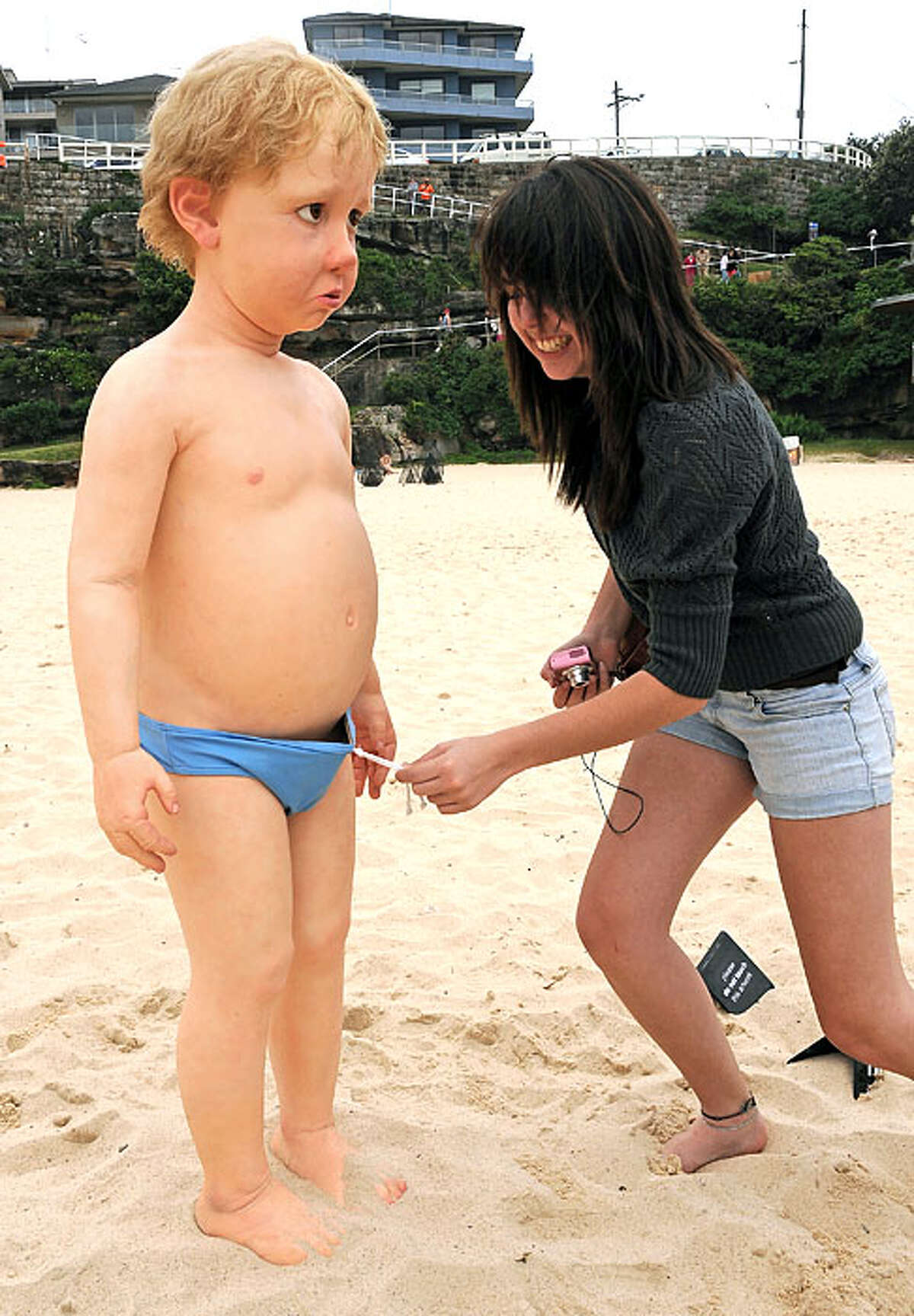 Curiousity gets the better of an admirer of the silicon and fibreglass work 'Little Lost Boy' by Australian artist Paul Trefry after overly-cautious organisers put a swimming costume on the figure for the official launch of the 13th Sculpture By The Sea exhibition on Sydney's Tamarama Beach on October 29, 2009. The annual outdoor display features sculptures by 114 Australian and international artists and is expected to attract over 600,000 visitors before closing on November 15.