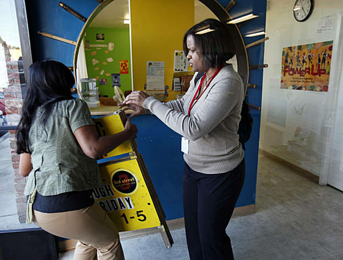 Dr. Ayanna Bennett (right) helps bring in the open sign of the clinic with therapist Aliya Sheriff when it closed Tuesday February 1, 2011. The 3rd Street Youth Center and Clinic has been operating in the Bayview district of San Francisco, Calif., is celebrating their fifth year serving young people.