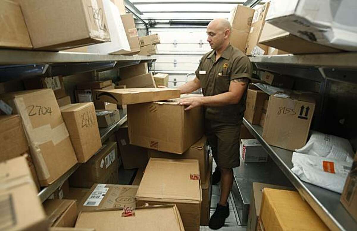 FILE - In this Oct. 18, 2010 photo, United Parcel Service (UPS) driver Paul Musial sorts packages in his truck in Palo Alto, Calif. UPS said Tuesday, Feb, 1, 2011, its fourth-quarter net income jumped 48 percent as shipments grew across the globe during the critical holiday season.