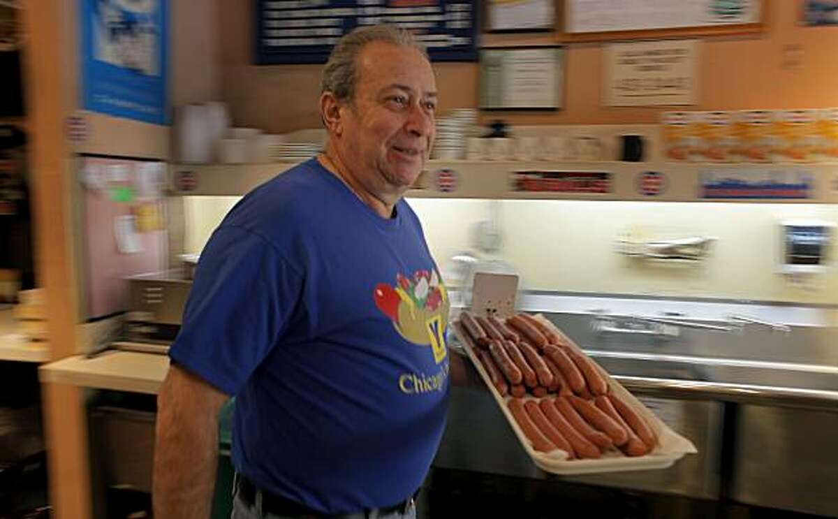 Joe Sattler, owner of Moishe'e Pippic Deli carries a tray of Vienna hotdogs which is make genuine Chicago Dogs, Tuesday Feb. 22, 2011, in San Francisco, Calif. Sattler is from Brazil, but wanted to open a Chicago style deli, because New York delis are more common, so he has filled his with Chicago memorabilia most of which came from customers.