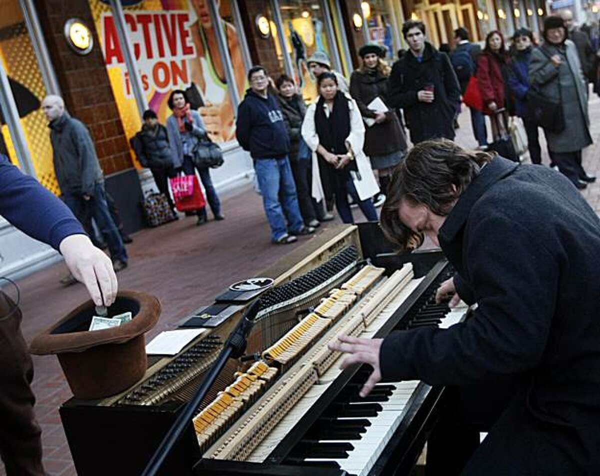 John "Thatcher" Boomer, hits the keyboards as he and his friend John Morgan not in photo, play their upright Wurlitzer piano for tips on San Francisco's Market Street. Friday Jan 7, 2011