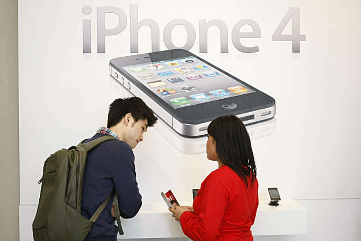 Hanmaro Kim (left) receives help purchasing an iPhone 4 at the Verizon Wireless store on Market Street in San Francisco Calif. on Thursday, Feb. 10, 2011.