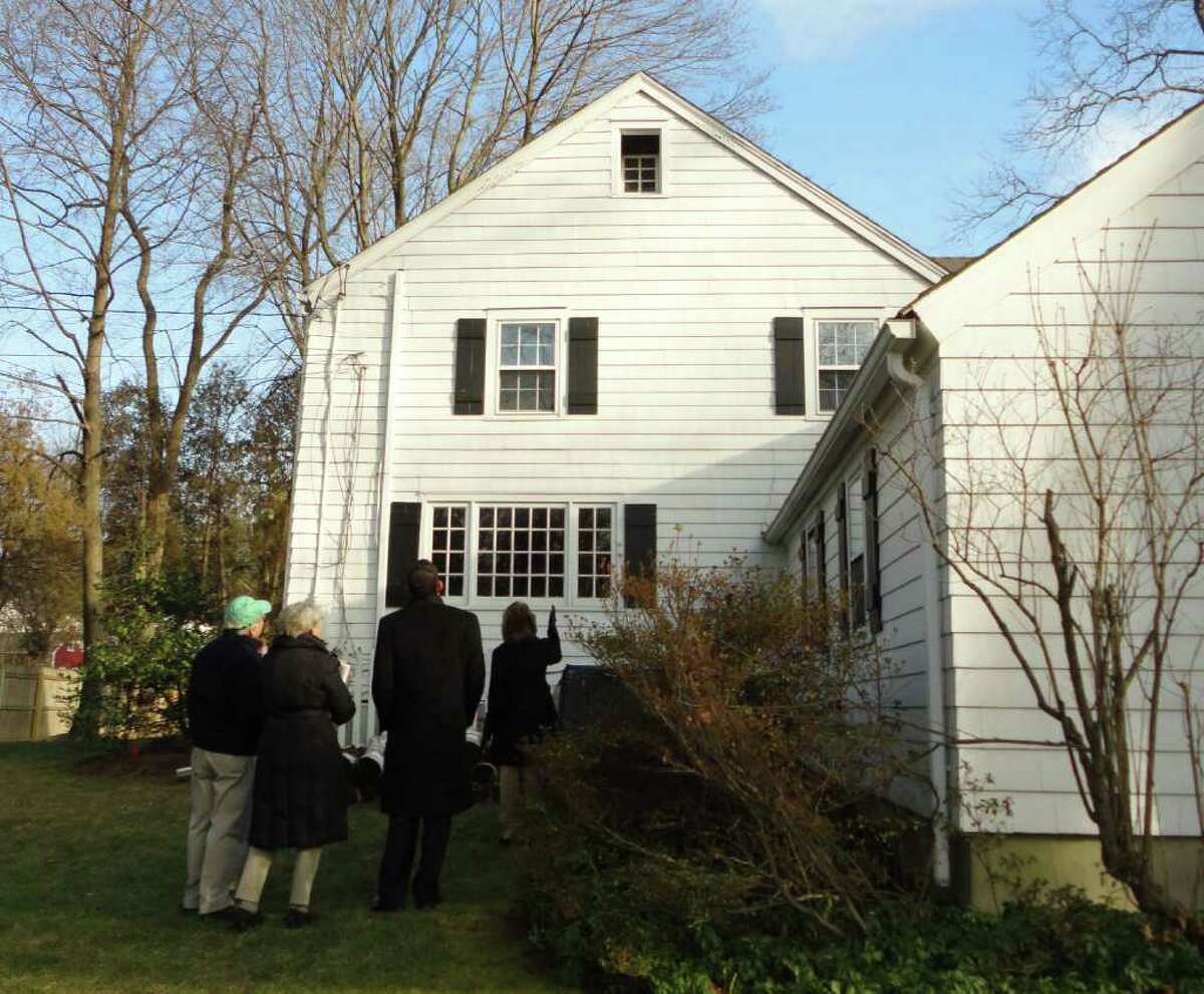 Members of the Westport Historic District Commission discuss architectural features of the historic saltbox house at 108 Cross Highway during a tour of the property conducted Wednesday by the homeowner David Lewis (center, black jacket, back to camera).