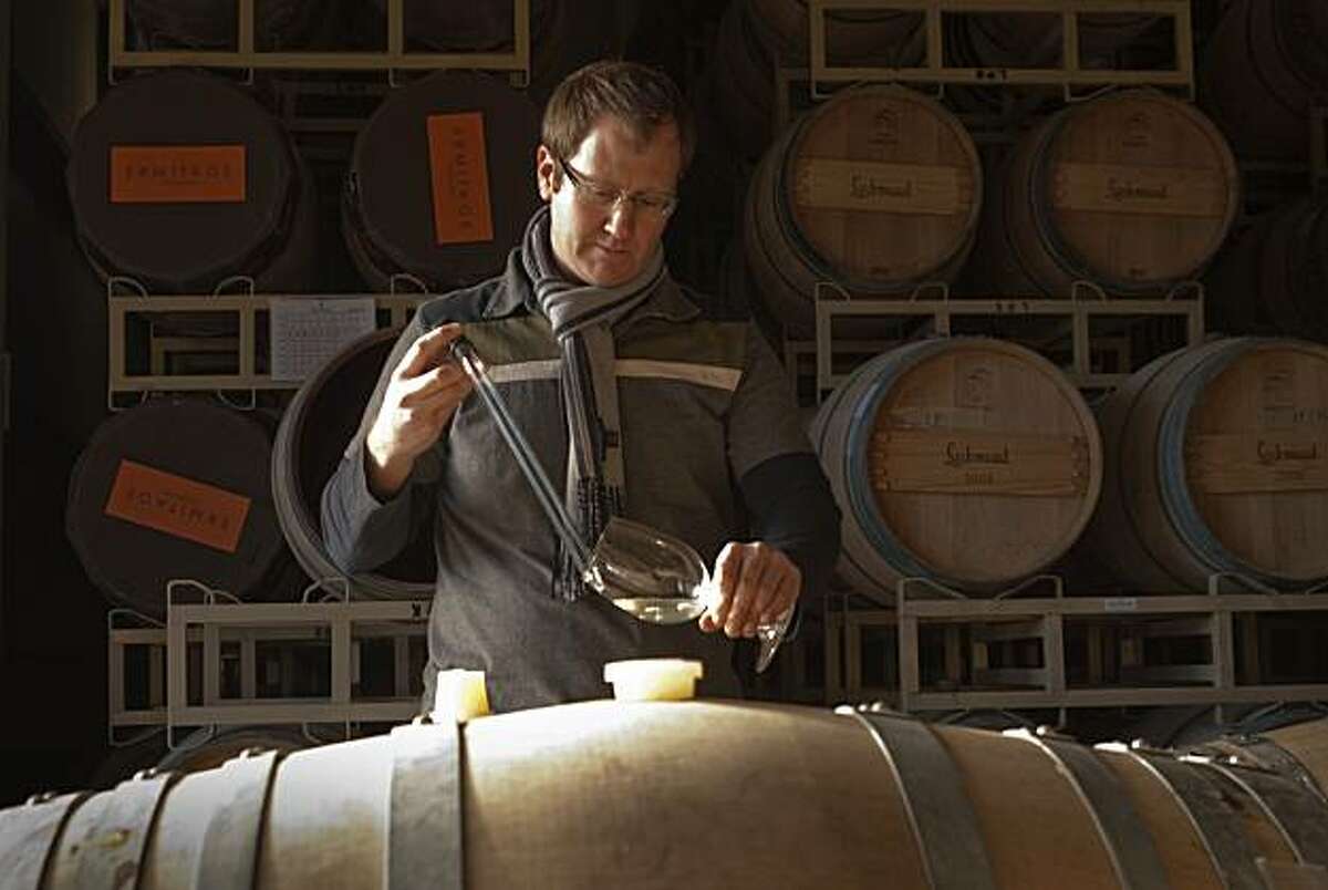Massican winemaker Dan Petroski takes a sample from a barrel of his wine for tasting Monday, Jan. 3, 2011 in Calistoga.