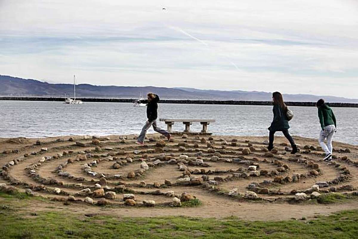 L-R, cousins, Kerry Walker, Katie Herskovitz, and Robin Walker, run around a labyrinth on the shore of Pillar Point Harbor near Half Moon Bay, Calif., on Friday, December 24, 2010. Urban Outings feature on Pillar Point, near Half Moon Bay. If you're tired of cold, gray Bay Area beaches with crashing waves, stroll out to sheltered, peaceful Pillar Point where gentle currents lap at a sandy beach and delicate clam shells crunch underfoot. Protected by Pillar Point Harbor, Pillar Point is part of the Fitzgerald Marine Reserve, which extends from the Montara light station south to Pillar Point.