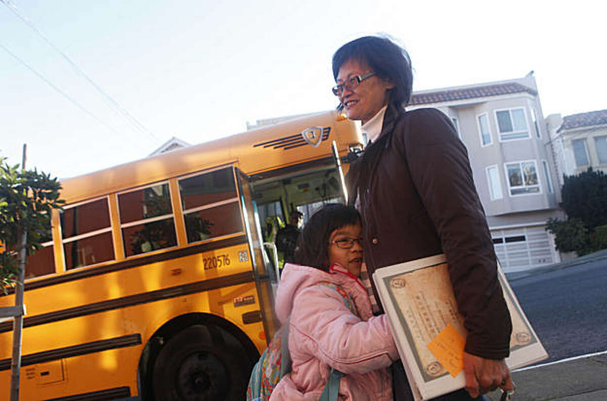 Lely Ma (right), Chinese librarian, gets a hug from Chloe Vuong (foreground left), 7, while greeting children as they disembark from a school bus as they arrive for school at Alice Fong Yu Elementary School on Tuesday, January 4, 2011 in San Francisco, Calif.