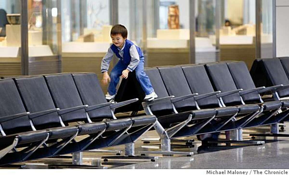 Six year old Matthew Kuo of Sunnyvale, along with his younger sister Tiffany (not seen) play on the empty seats in the International Terminal at the San Francisco International Airport on a quiet day before Thanksgiving, Wednesday, November 26, 2008.